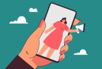 Hand holding phone with woman speaking into megaphone on screen min scaled