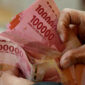 A man counts Indonesian rupiah banknotes at a currency exchange office in Jakarta, Indonesia, on Thursday, Oct. 5, 2023. The dollar’s relentless rally has finally toppled the last Asian currency standing, with the Indonesian rupiah joining regional peers in erasing this year’s gains against the greenback. Photographer: Dimas Ardian/Bloomberg