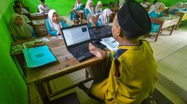 Untung, seorang guru difabel, mengoperasikan laptop dengan kaki kanannya saat mengajar di Madrasah Ibtidaiyah (MI) Miftahul Ulum Batang-batang, Sumenep, Madura, Jawa Timur, Rabu (19/10/2022). Saat ini jumlah tenaga kerja aktif yang terdaftar di BPJAMSOSTEK mencapai 35 juta pekerja, sedangkan target untuk tahun 2026 BPJAMSOSTEK bisa memberikan perlindungan jaminan sosial kepada 70 juta pekerja.