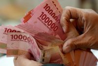 A man counts Indonesian rupiah banknotes at a currency exchange office in Jakarta, Indonesia, on Thursday, Oct. 5, 2023. The dollar’s relentless rally has finally toppled the last Asian currency standing, with the Indonesian rupiah joining regional peers in erasing this year’s gains against the greenback. Photographer: Dimas Ardian/Bloomberg