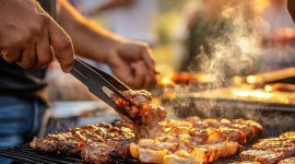 man grilling meat on outdoor barbecue